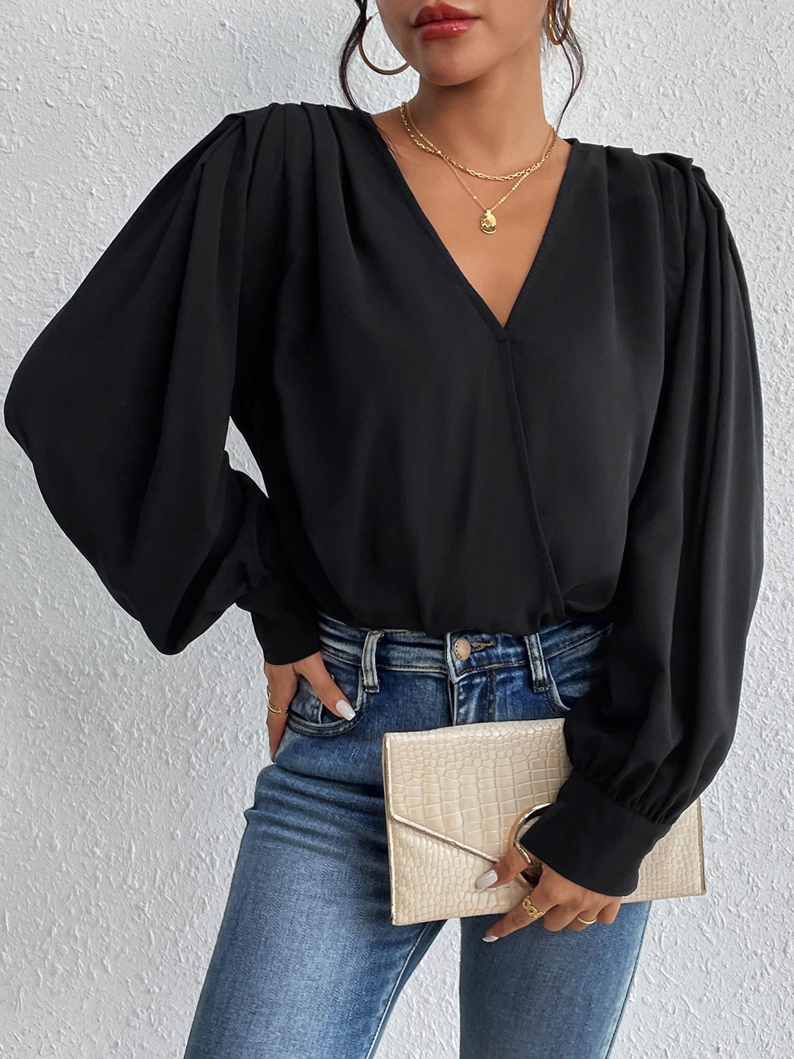 Black balloon sleeve surplice bodysuit with V-neck and cinched cuffs.
