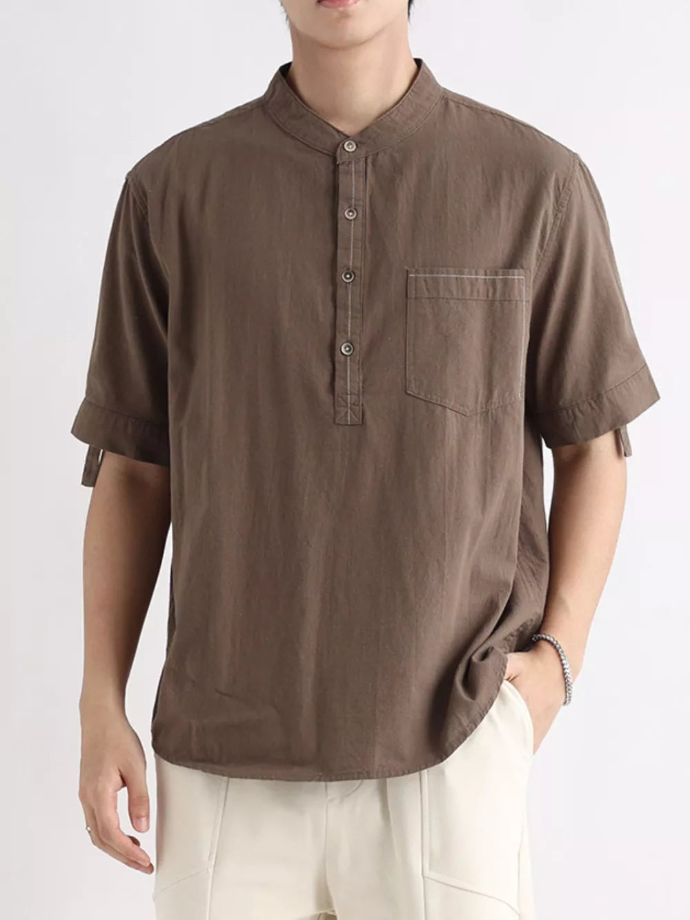 Brown cotton short sleeve banded collar shirt with button placket and chest pocket.