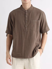 Brown cotton short sleeve banded collar shirt with button placket and chest pocket.