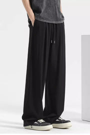 Black sweatpants with drawstring and pockets, styled with a t-shirt and sneakers.