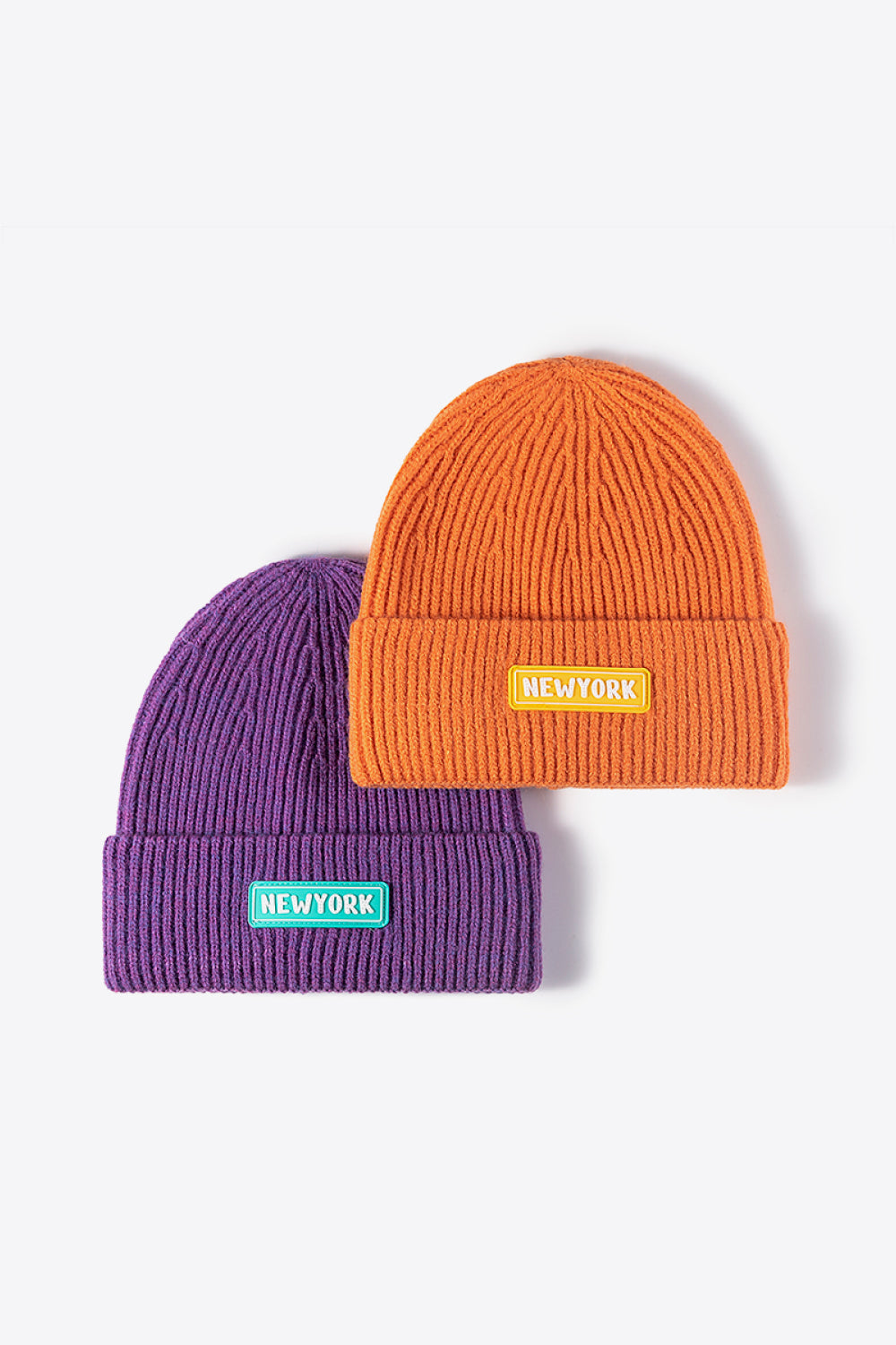 Purple and orange ribbed beanies with New York patches.