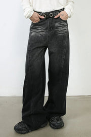 Dark denim palazzo trousers with a wide leg and sculpted seams, styled with a belt.