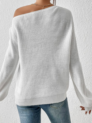 White ribbed knit off-shoulder top with balloon sleeves and a gold necklace.