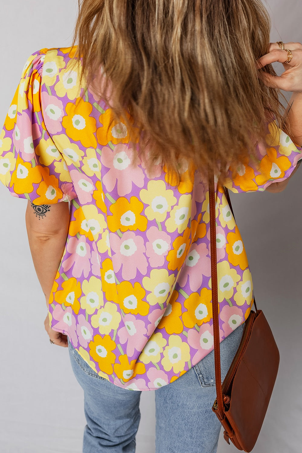 Puff sleeve blouse with a bold floral print in pink, yellow, and purple.