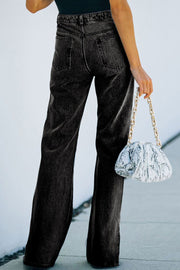 Flared hem slit denim trousers in dark wash, shown from the back.