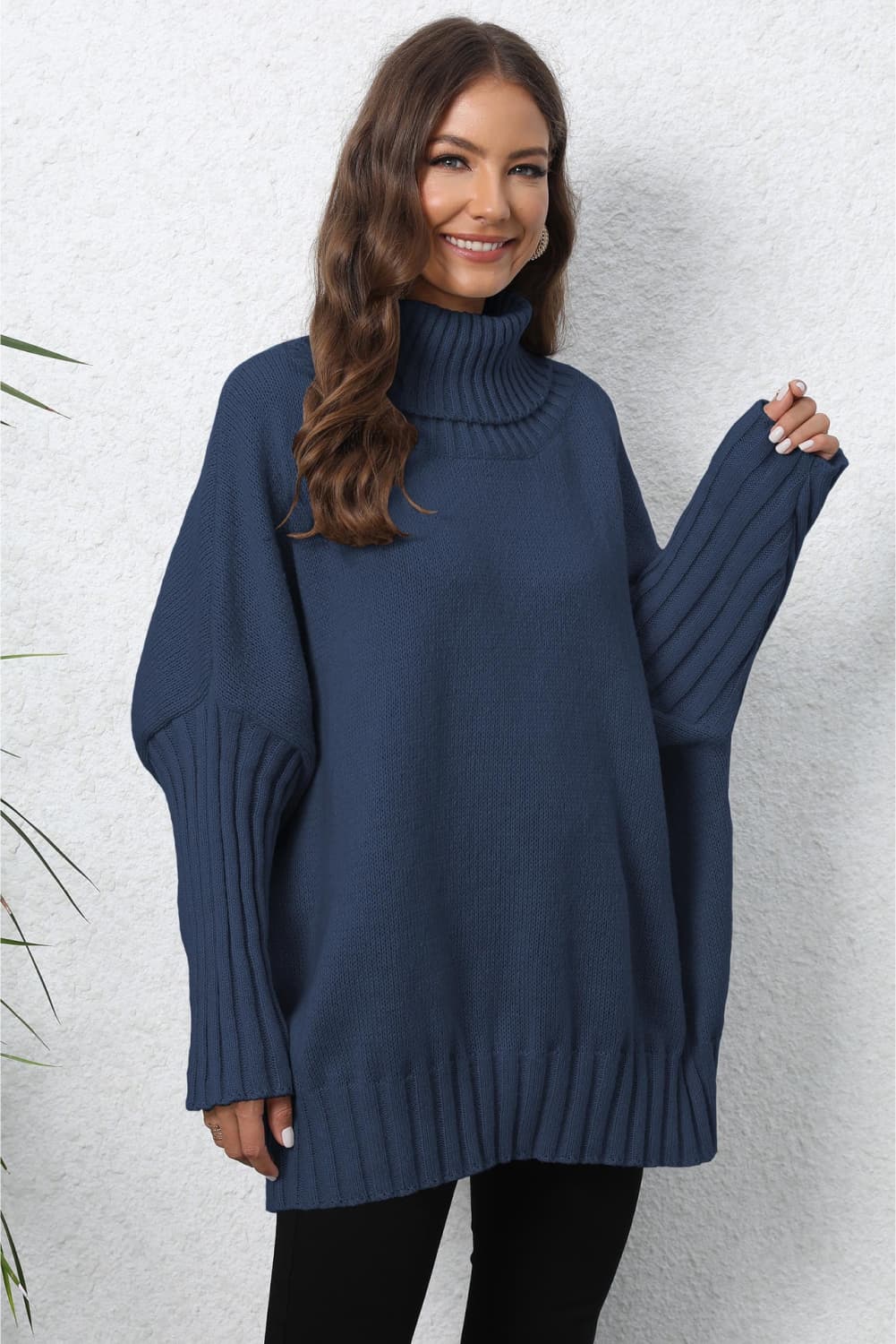 Dark blue ribbed turtleneck sweater with batwing sleeves and ribbed cuffs.