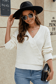 Ivory knit wrap v-neck pullover sweater with textured sleeves and ribbed cuffs.