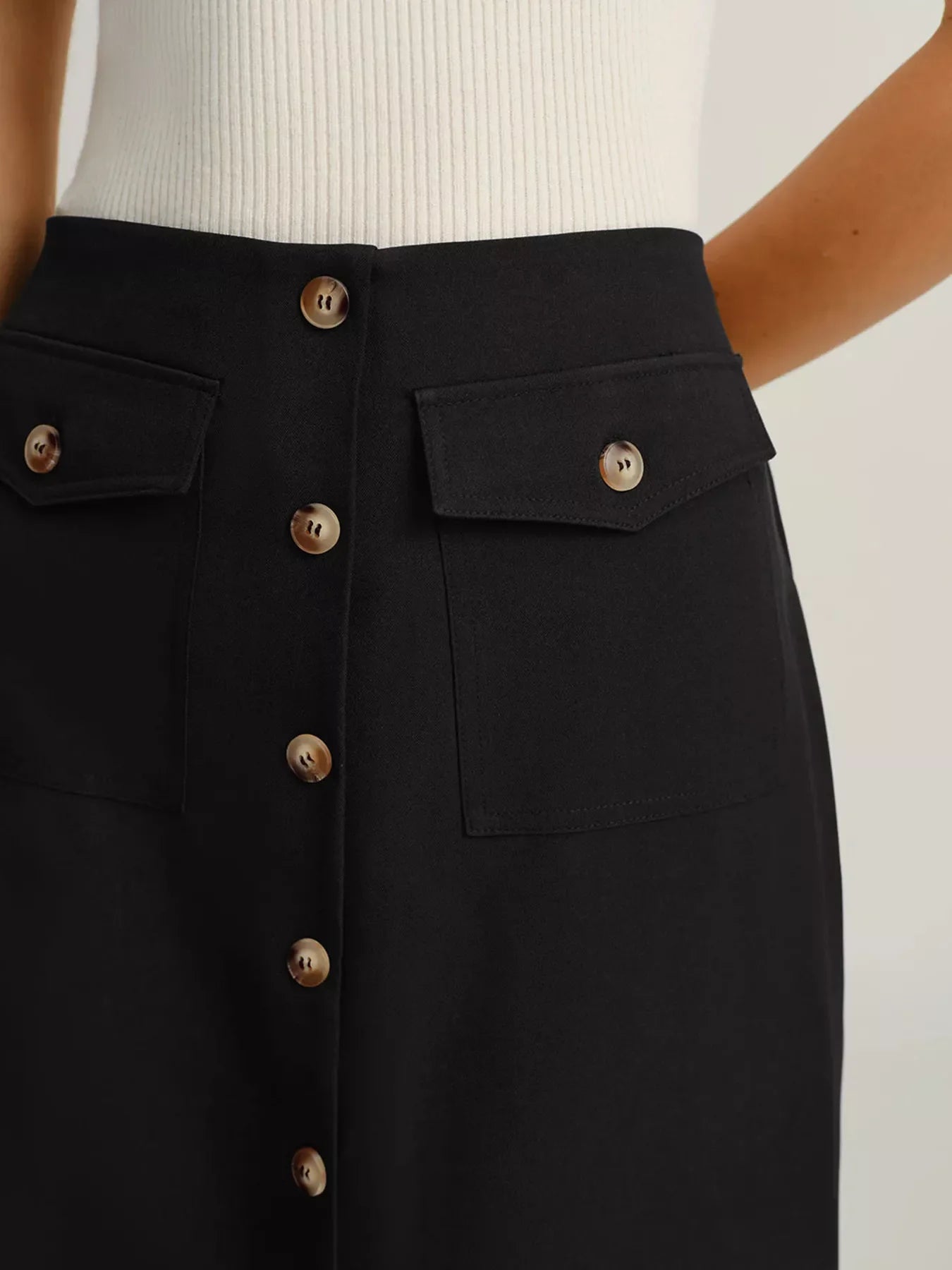 Black button-front midi skirt with patch pockets and button details.