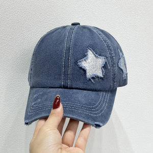 Dusty blue denim baseball cap with distressed details and glitter star patches.