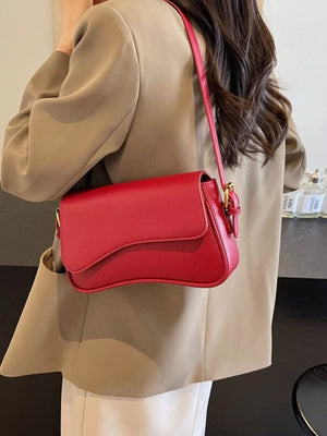 Red faux leather crossbody bag with flap closure and gold buckle detail.
