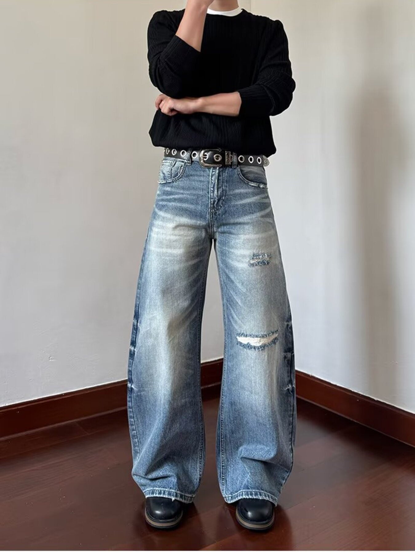 Men's blue distressed wide-leg jeans with ripped details and a relaxed fit.