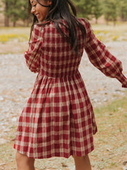 Red plaid cotton mini dress with smocked bodice and puff sleeves.