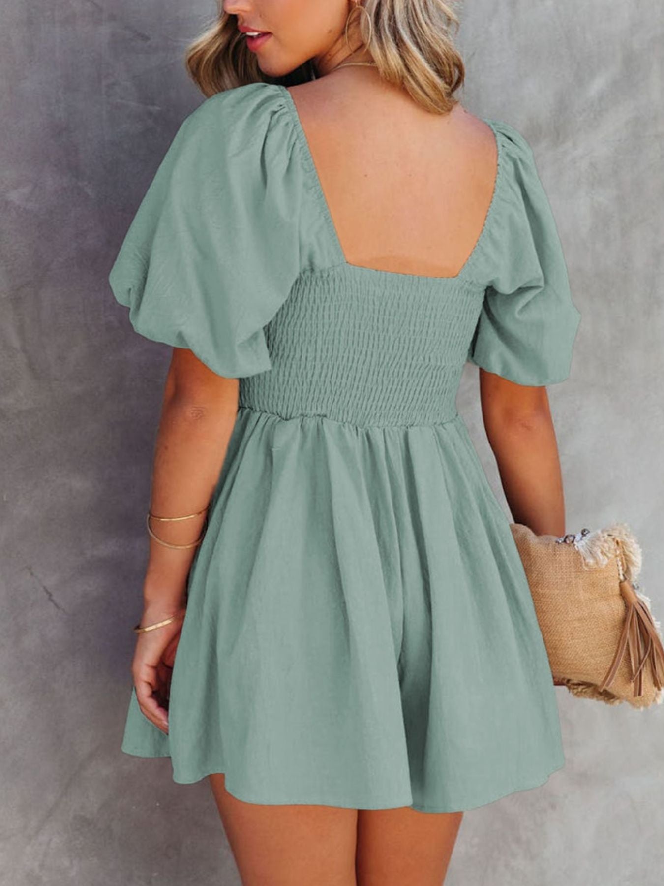 Sage ruched puff sleeve square neck romper with smocked bodice and flared shorts.