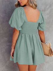 Sage ruched puff sleeve square neck romper with smocked bodice and flared shorts.