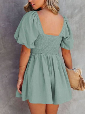 Sage ruched puff sleeve square neck romper with smocked bodice and flared shorts.