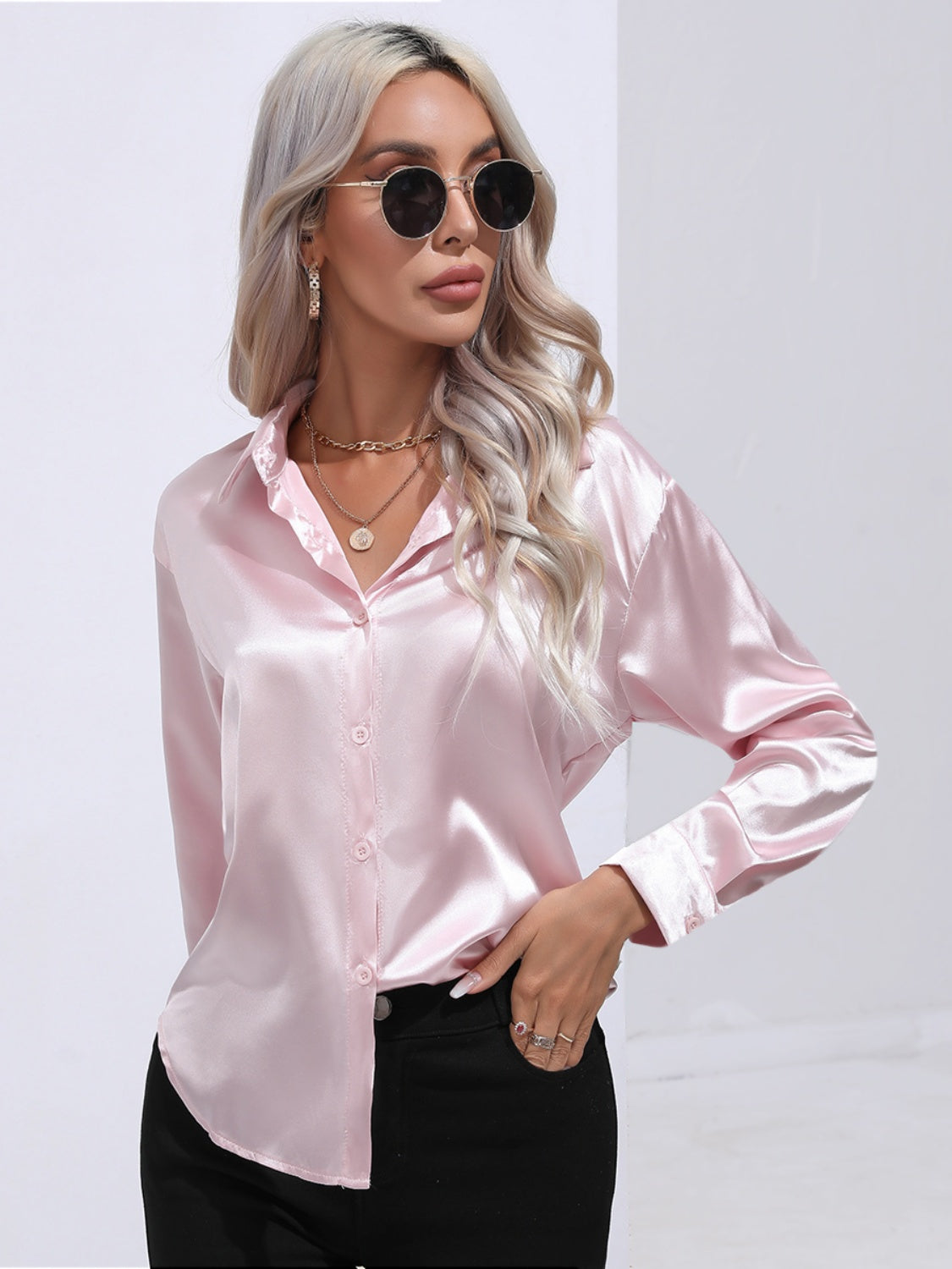 Blush pink satin button-front blouse with a collared neckline and long sleeves.