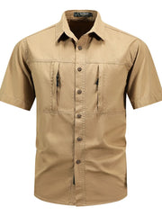 Men's tan cotton short sleeve button-down shirt with two zippered chest pockets.