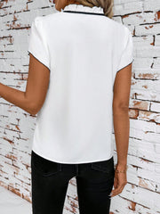 White maternity blouse with ruffled tie-neck and black trim, short sleeves.