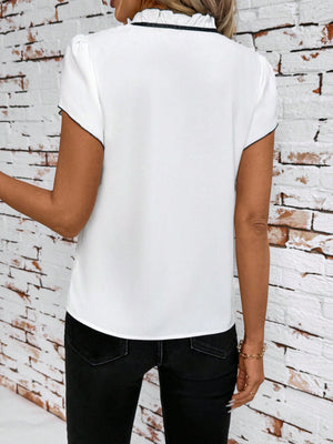 White maternity blouse with ruffled tie-neck and black trim, short sleeves.