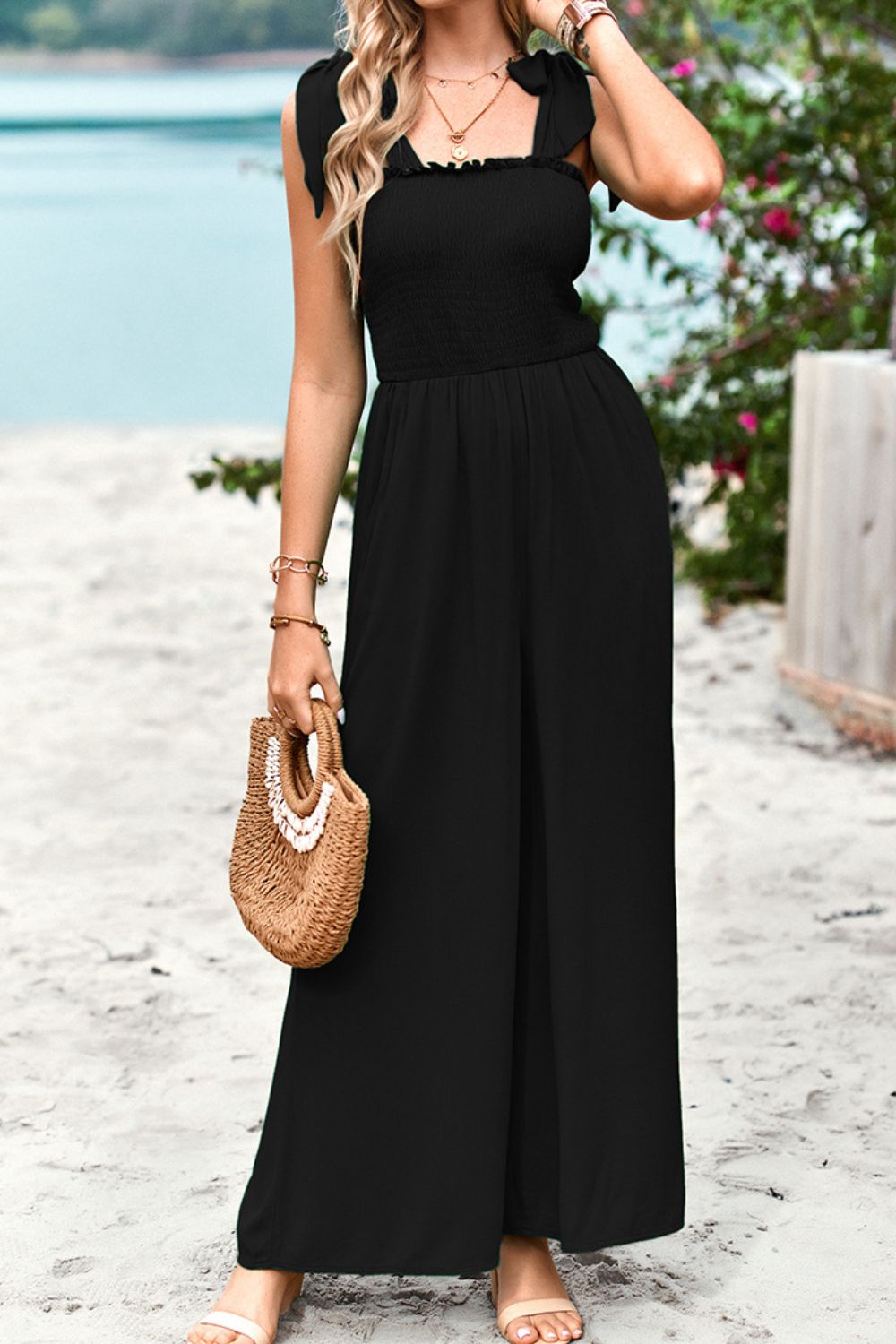 Black smocked bodice tie-strap palazzo jumpsuit with wide legs.