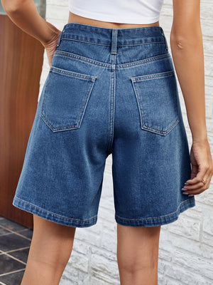 Pleated denim bermuda shorts in medium wash with button closure and back pockets.