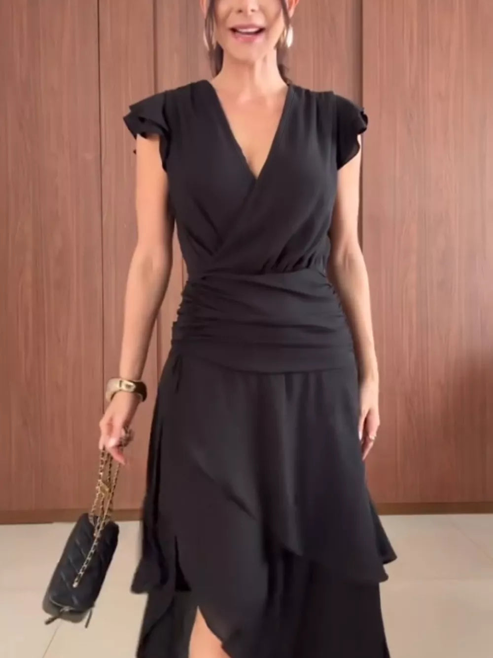 Black asymmetrical ruffle hem dress with cap sleeves and cinched waist detail.