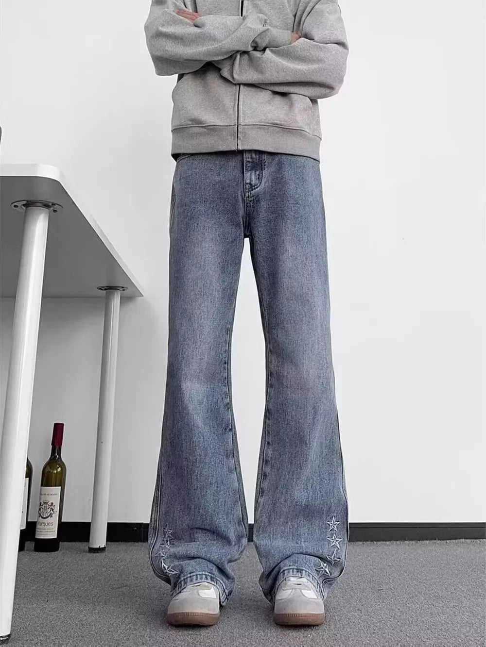 Blue wide-leg jeans with star embroidery detail on the hem.