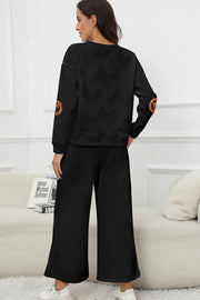 Black textured loungewear set with pumpkin patch sleeve detail.