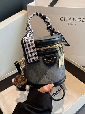 Quilted mini bucket bag in black with checkered scarf detail and charm.