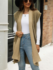 Textured knit sleeveless cardigan vest in tan with ribbed trim and pockets.