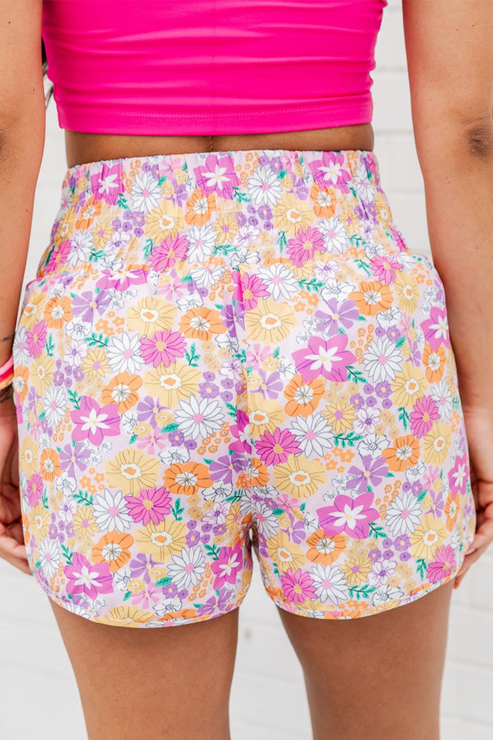 Floral print shorts with scalloped hem and elastic waist in pink, gold, and purple flowers.
