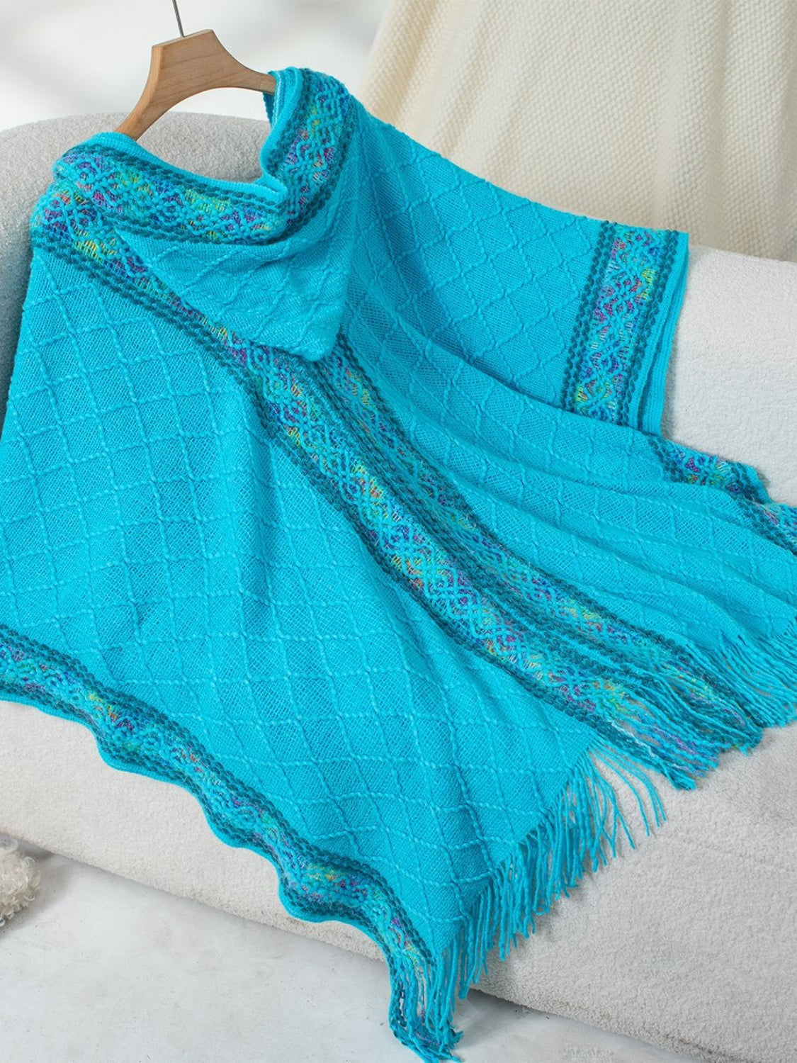 Sky blue knit hooded wrap with diamond pattern and colorful embroidered trim.