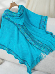 Sky blue knit hooded wrap with diamond pattern and colorful embroidered trim.