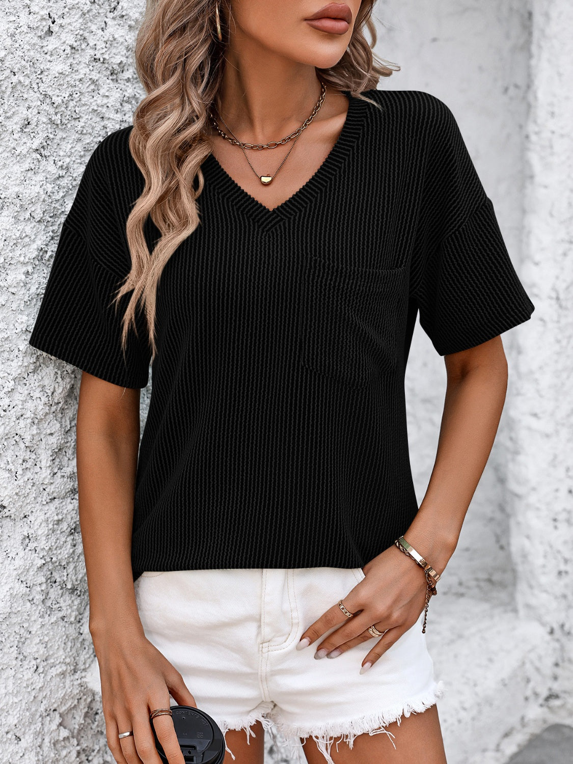 Black ribbed V-neck t-shirt with a chest pocket and short sleeves.
