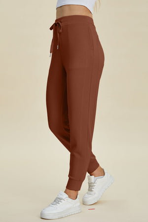 Caramel joggers with drawstring waist and cuffed ankles, styled with white sneakers.