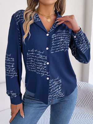 Dark blue collared blouse with white script print, button front, and long sleeves.