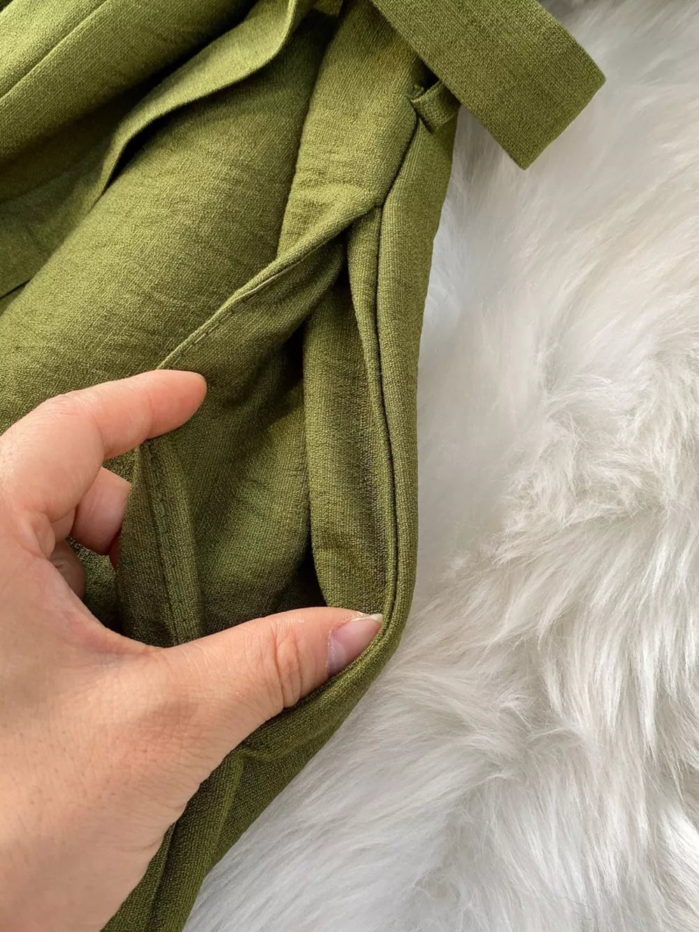 Green V-neck wide leg jumpsuit with belt and pockets.