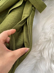 Green V-neck wide leg jumpsuit with belt and pockets.