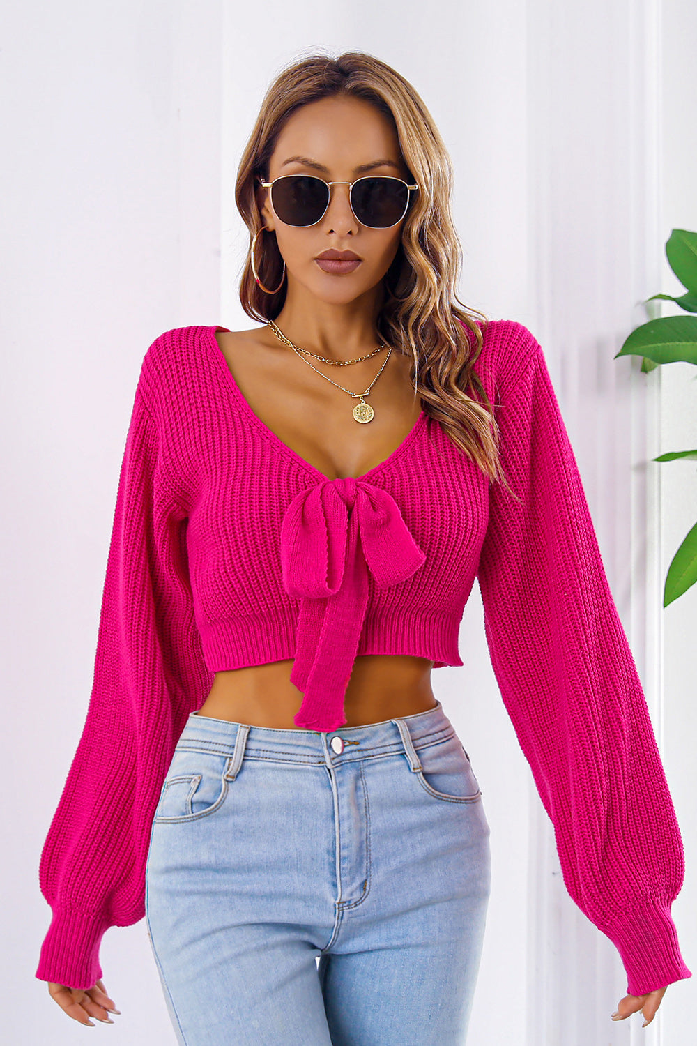 Tie-front balloon sleeve crop knit sweater in Deep Rose acrylic with V-neck.