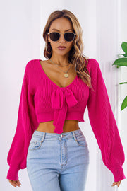 Tie-front balloon sleeve crop knit sweater in Deep Rose acrylic with V-neck.