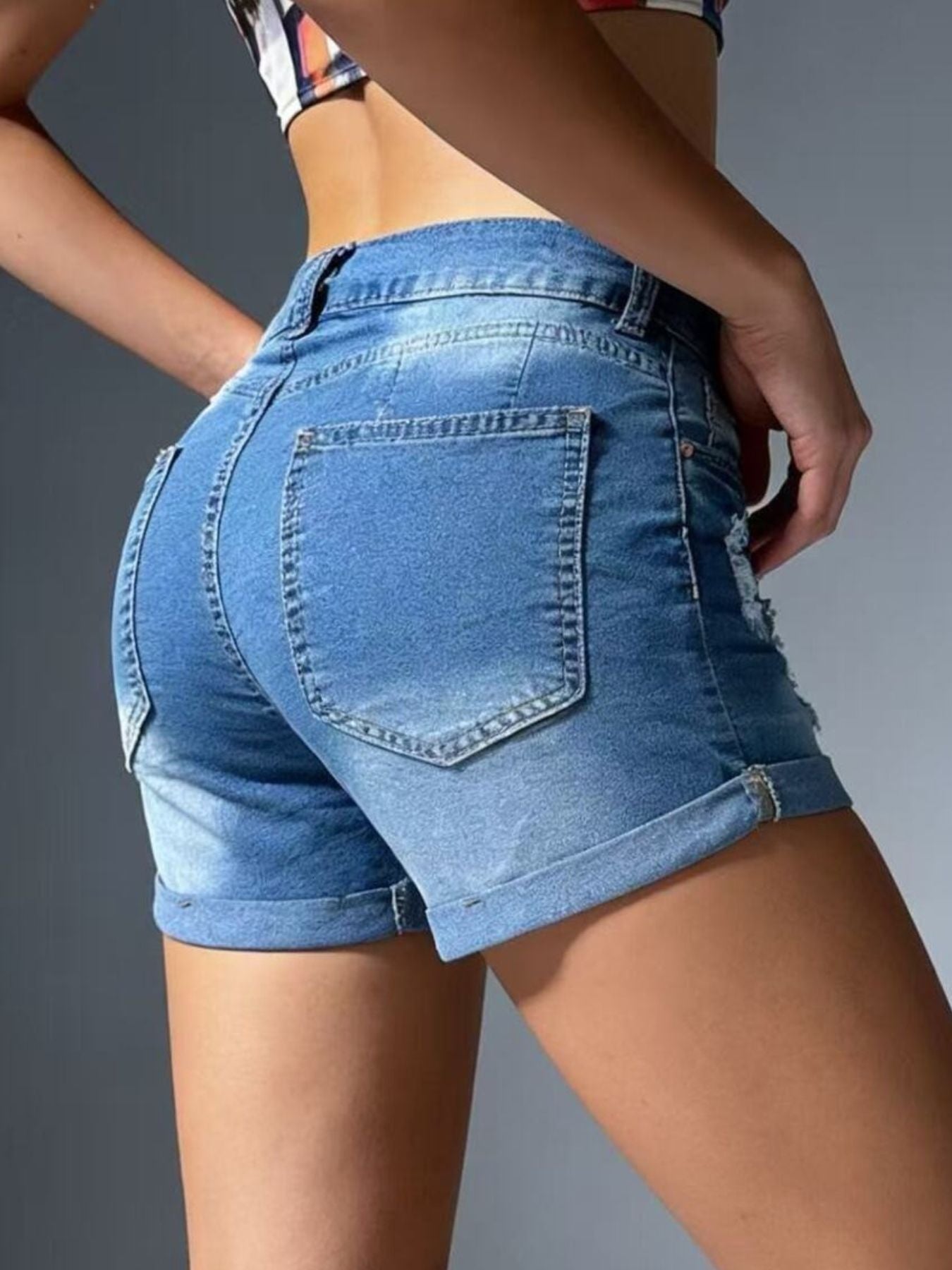 Light blue distressed denim shorts with cuffed hem and distressed details.