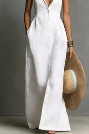 Chic white sleeveless maxi dress with button front and pockets, styled with a straw hat.