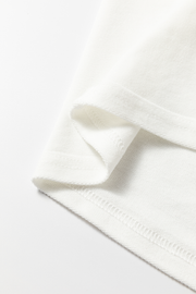White sweatshirt detail showing fabric texture and stitching