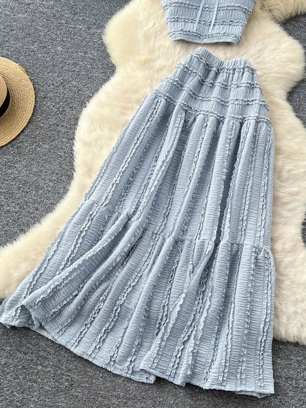 Blue gray ruched polyester crop top and maxi skirt set with frill details.