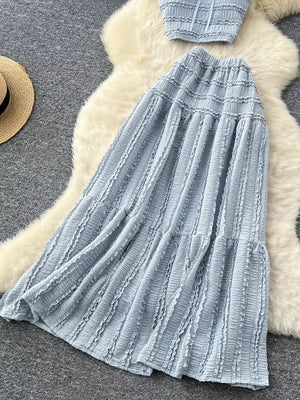 Blue gray ruched polyester crop top and maxi skirt set with frill details.