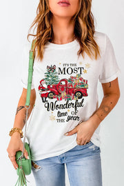 White graphic tee with festive Christmas truck, Santa, tree, and gifts design.
