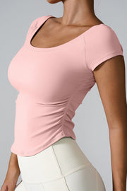 Blush pink performance tee with gathered side detail and short sleeves