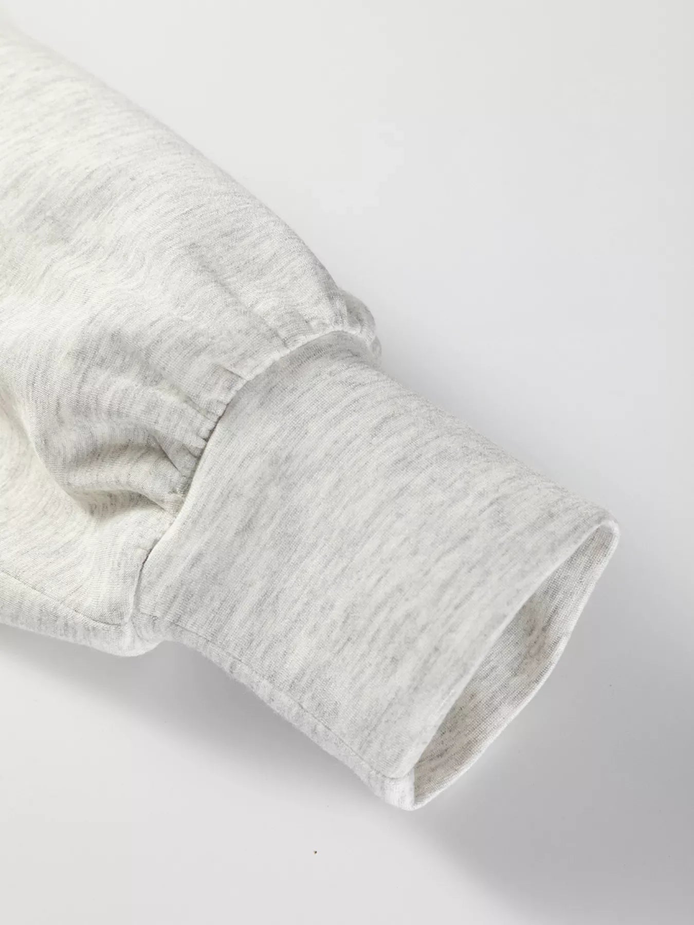 Light gray tunic sweatshirt sleeve with gathered detail and ribbed cuff.