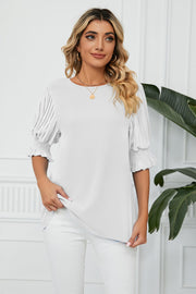 White blouse with pleated sleeves and smocked cuffs
