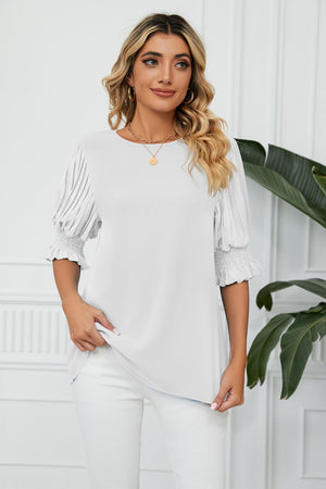 White blouse with pleated sleeves and smocked cuffs